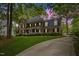 A grand brick home with dormers and a manicured front lawn, exuding classic charm at 7709 Oakmont Pl, Raleigh, NC 27615