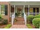 Charming front entrance with brick steps, white railing, and manicured shrubbery at 7709 Oakmont Pl, Raleigh, NC 27615