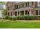 Classic brick home with charming front porch, American flag, and manicured landscaping at 7709 Oakmont Pl, Raleigh, NC 27615