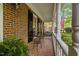 Inviting front porch with seating, brick flooring, and lush greenery at 7709 Oakmont Pl, Raleigh, NC 27615