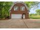 A home's red brick, rear-entry garage with a white door and concrete driveway at 7709 Oakmont Pl, Raleigh, NC 27615