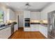 Well-lit kitchen with stainless steel appliances, white cabinets and hardwood floors at 7709 Oakmont Pl, Raleigh, NC 27615