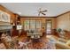 Cozy living room features a brick fireplace, built-in shelves, and a ceiling fan at 7709 Oakmont Pl, Raleigh, NC 27615