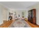 Spacious living room showcasing hardwood floors, a Persian rug, and seating near sunny windows at 7709 Oakmont Pl, Raleigh, NC 27615