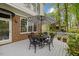 Charming patio with black metal furniture, a striped umbrella, and surrounding greenery at 7709 Oakmont Pl, Raleigh, NC 27615