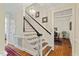 Elegant staircase with hardwood steps, black railings, and white trim at 7709 Oakmont Pl, Raleigh, NC 27615