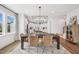 Formal dining room with hardwood floors, modern chandelier, large windows and staircase at 801 Hyperion Aly, Wake Forest, NC 27587