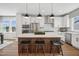 Bright kitchen with stainless steel appliances, white cabinetry, hardwood floors and a large kitchen island at 801 Hyperion Aly, Wake Forest, NC 27587