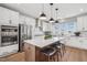 Bright kitchen with stainless steel appliances, white cabinetry, hardwood floors and a large kitchen island at 801 Hyperion Aly, Wake Forest, NC 27587