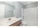 Bathroom with dark wood cabinets, a tub-shower combo, and a white toilet at 8021 Crookneck Dr, Angier, NC 27501