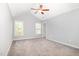 Spacious bedroom featuring a ceiling fan, plush carpet, and two sunlit windows at 8021 Crookneck Dr, Angier, NC 27501