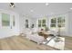 Bright living room with large windows, hardwood floors, and stylish white furniture at 811 Fireship Rd, Fuquay Varina, NC 27526