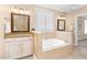 Elegant bathroom with a built-in bathtub, shuttered window, and dual vanities with granite countertops at 88 Eltham, Rocky Mount, NC 27804
