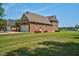 Expansive brick home with an attached garage and a large, well-manicured lawn under a clear, blue sky at 88 Eltham, Rocky Mount, NC 27804