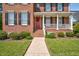 Inviting entrance featuring a red door adorned with a wreath, complemented by lush landscaping and a well-maintained lawn at 88 Eltham, Rocky Mount, NC 27804
