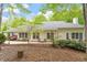 The beautiful backyard features a brick patio, trimmed bushes and a lush wooded area at 919 Woodham, Pittsboro, NC 27312
