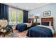 Bright bedroom with twin beds, blue accents, and a large window view at 919 Woodham, Pittsboro, NC 27312