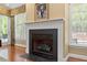 Cozy fireplace in a naturally lit room with large windows and classic design at 919 Woodham, Pittsboro, NC 27312