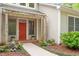 Inviting entrance with brick pathway, vibrant red door and lion statues at 919 Woodham, Pittsboro, NC 27312