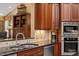 Kitchen area with custom cabinets, granite countertops, tile backsplash and stainless steel appliances at 919 Woodham, Pittsboro, NC 27312