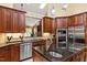 Kitchen featuring stainless steel appliances, custom wooden cabinets and granite countertops at 919 Woodham, Pittsboro, NC 27312