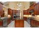 Gourmet kitchen featuring stainless steel appliances, an island, tile backsplash and wooden cabinets at 919 Woodham, Pittsboro, NC 27312