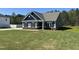 A single-story home with a blue exterior, traditional design, well-maintained lawn, and a backdrop of lush trees at 95 Knoll Way, Sanford, NC 27332