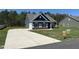 New home with a long driveway, attached garage, well-kept lawn, and visible signage for available properties at 95 Knoll Way, Sanford, NC 27332