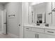 Modern bathroom features white cabinets, modern fixtures and a large mirror at 956 The Parks Dr, Pittsboro, NC 27312