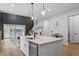 Open kitchen with island, quartz countertop, stainless appliances, and seamless flow to living areas at 956 The Parks Dr, Pittsboro, NC 27312