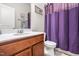 Close-up of bathroom featuring a cherry vanity with white countertop, toilet, and shower curtain at 1018 Sweet Cream Ct, Durham, NC 27703