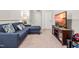 Cozy living room features a comfortable blue sofa, a TV with decorative stand, and neutral carpet at 1018 Sweet Cream Ct, Durham, NC 27703