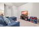 Cozy living room features a comfortable blue sofa, a TV with decorative stand, and neutral carpet at 1018 Sweet Cream Ct, Durham, NC 27703