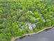 Aerial home view amidst dense trees near a lake, offering scenic privacy and tranquility at 102 Windrock Lane, Cary, NC 27518