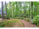 Lush backyard featuring mature trees, grass, landscape beds, and private, wooded setting at 102 Windrock Lane, Cary, NC 27518