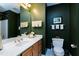 Bathroom featuring dark green walls, marble-look countertop, toilet, and shower with curtain at 102 Windrock Lane, Cary, NC 27518