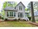Back exterior showcasing deck, bay windows, lush trees, and privacy at 102 Windrock Lane, Cary, NC 27518