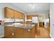 Functional kitchen featuring light wood cabinetry, granite counters, and an open layout for easy access at 102 Windrock Lane, Cary, NC 27518