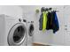Bright laundry room with washer, dryer, and built-in storage and hanging rack at 102 Windrock Lane, Cary, NC 27518