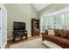 Cozy living room area with a TV and media console, perfect for relaxation and entertainment at 102 Windrock Lane, Cary, NC 27518
