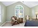 Bright main bedroom with a vaulted ceiling, seating area, and large arched window at 102 Windrock Lane, Cary, NC 27518