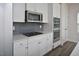 Modern kitchen features stainless steel microwave, gas cooktop, stylish backsplash and white shaker cabinets at 1020 Kentlands Dr, Durham, NC 27713