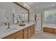 Bright bathroom with wood cabinets, double sinks, large mirror, glass-enclosed shower, and tile flooring at 103 Temple Gate Dr, Cary, NC 27518