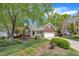 Charming brick home featuring a welcoming front porch, attached garage, and lush landscaping at 103 Temple Gate Dr, Cary, NC 27518