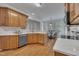 Open kitchen concept with wood cabinets, stainless appliances, quartz countertops, and hardwood floors at 103 Temple Gate Dr, Cary, NC 27518