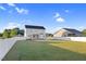 Expansive backyard with a white vinyl fence, lush green grass, a covered patio, and an external utility connection at 105 Blooms Way, Kenly, NC 27542