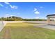 A well-maintained backyard featuring a white fence, lush green grass, and a patio at 105 Blooms Way, Kenly, NC 27542