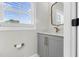 Well-lit powder room with a gray vanity, gold fixtures, and a window for natural light at 105 Blooms Way, Kenly, NC 27542
