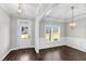Formal dining room with hardwood floors, elegant chandelier, wainscoting and a large window at 105 Blooms Way, Kenly, NC 27542