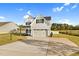 Two-story white farmhouse exterior featuring a two-car garage, wide driveway and manicured front lawn at 105 Blooms Way, Kenly, NC 27542